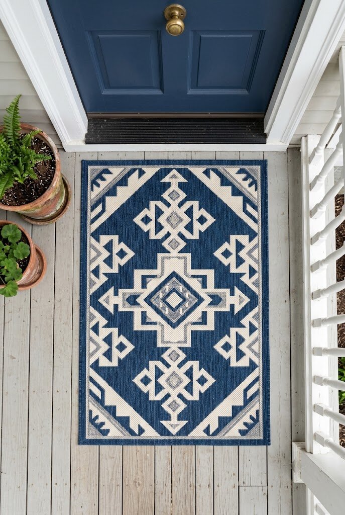 patterned outdoor rug in front of door on small painted front porch