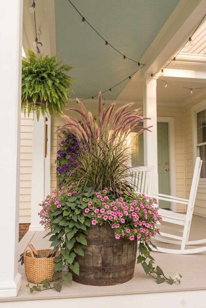 wine barrel planter with mixed flowers and ornamental grass on small front porch